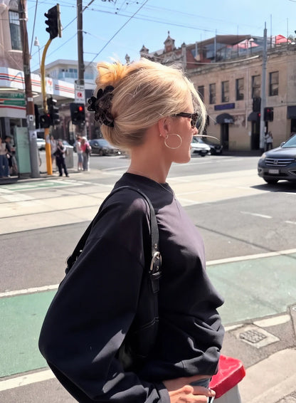 Woman with styled hair on a city street. Buttermilk Rebekah Claw Clip Coffee Table - The Rose Edit