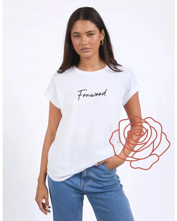 Woman wearing a white t-shirt with 'Foxwood' text and blue jeans on a white background
