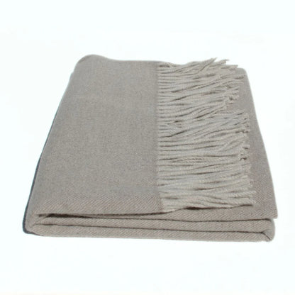 Folded gray blanket with fringed edge on a white background. Simple Scarf Taupe - The Rose Edit