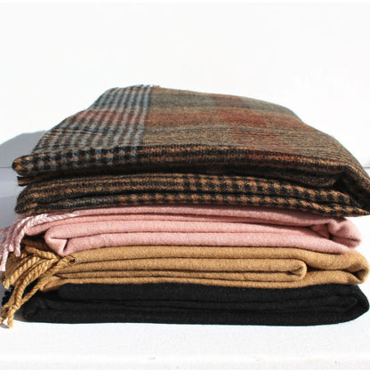 Stack of plaid and solid color blankets on a white background. Throw Scarf Tweed - The Rose Edit
