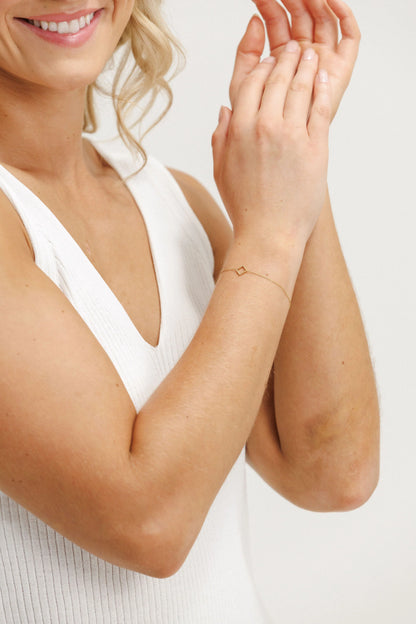 Woman wearing a delicate bracelet on a plain background