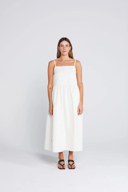 Woman wearing a white dress on a light gray background