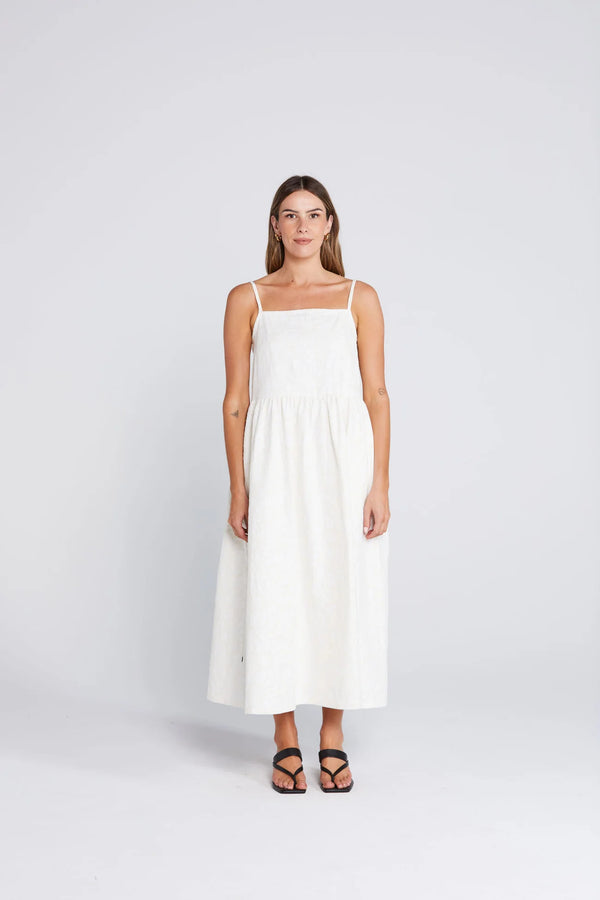 Woman wearing a white dress on a light gray background