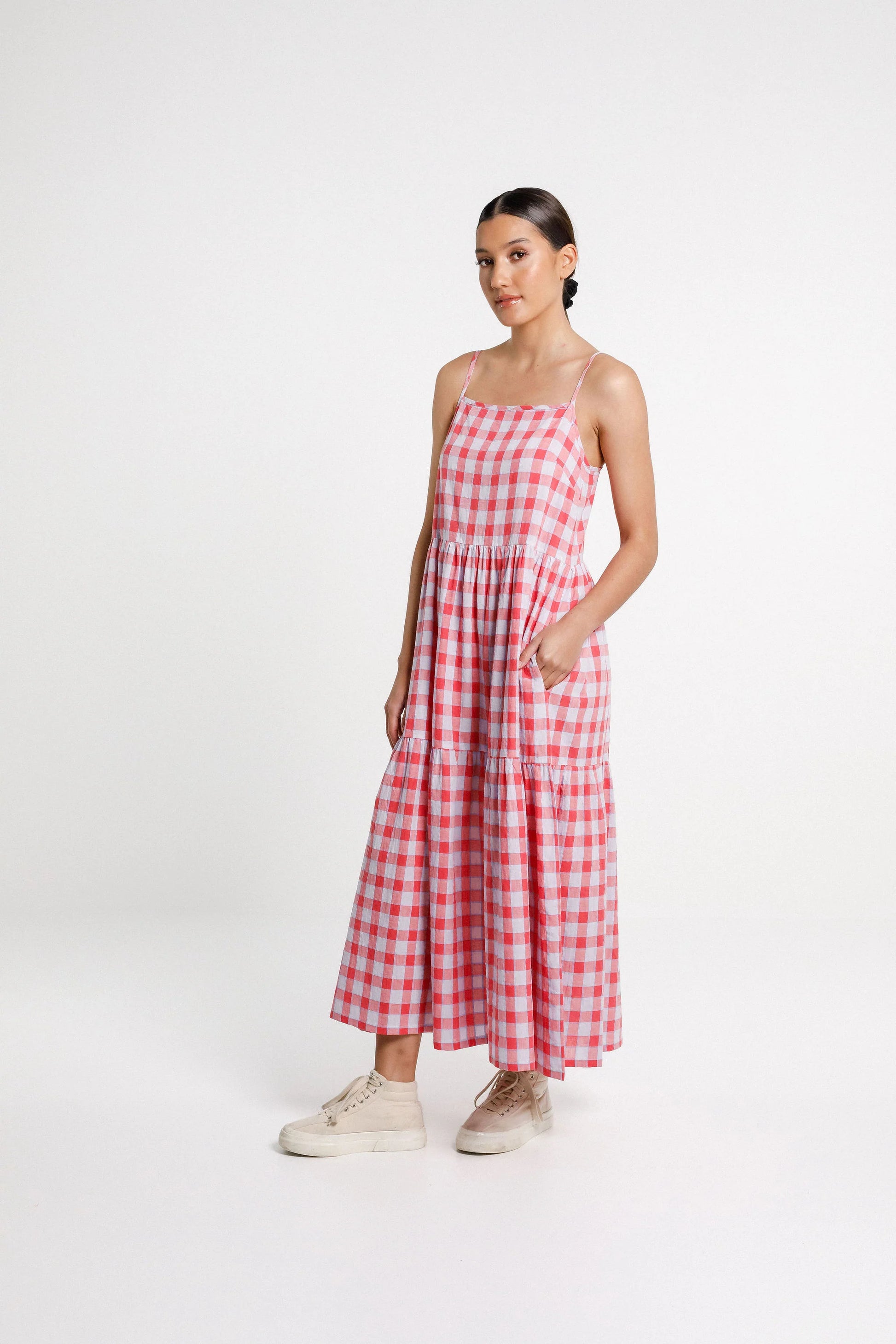 Woman wearing a red and white checkered dress on a white background