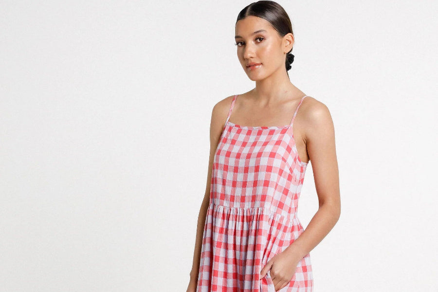 Woman wearing a red and white checkered dress on a white background