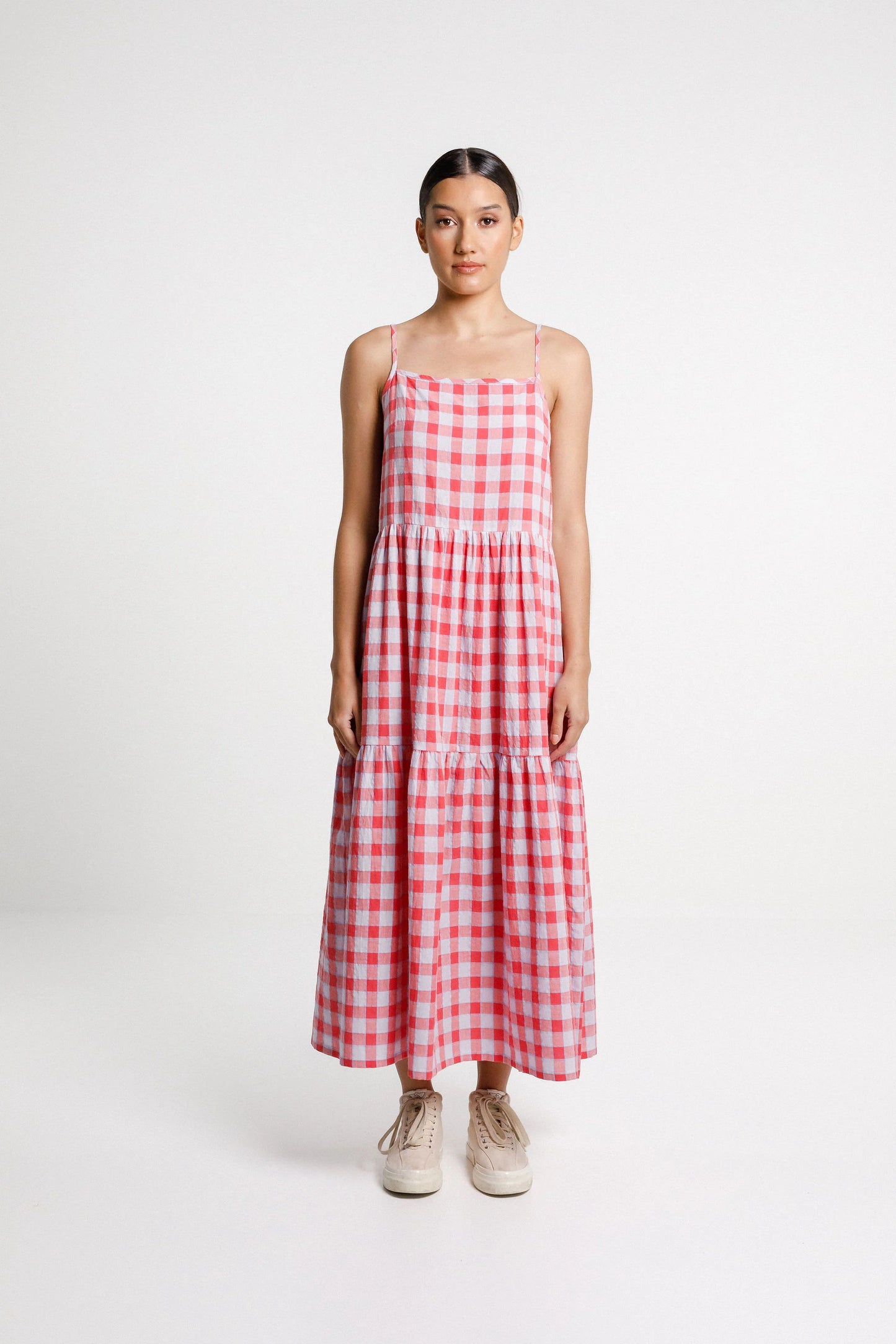 Woman wearing a red and white checkered dress on a white background