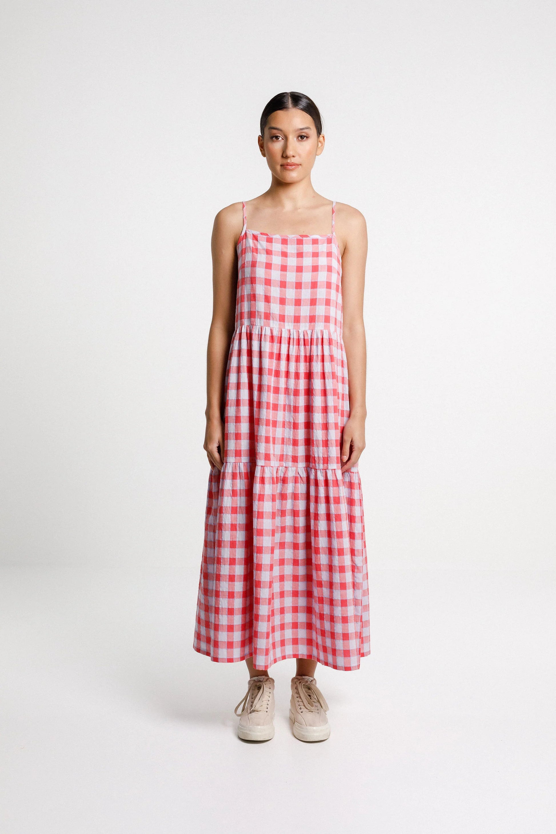 Woman wearing a red and white checkered dress on a white background
