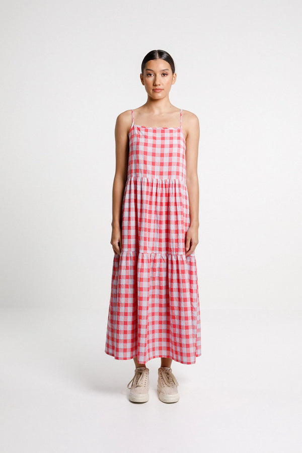 Woman wearing a red and white checkered dress on a white background