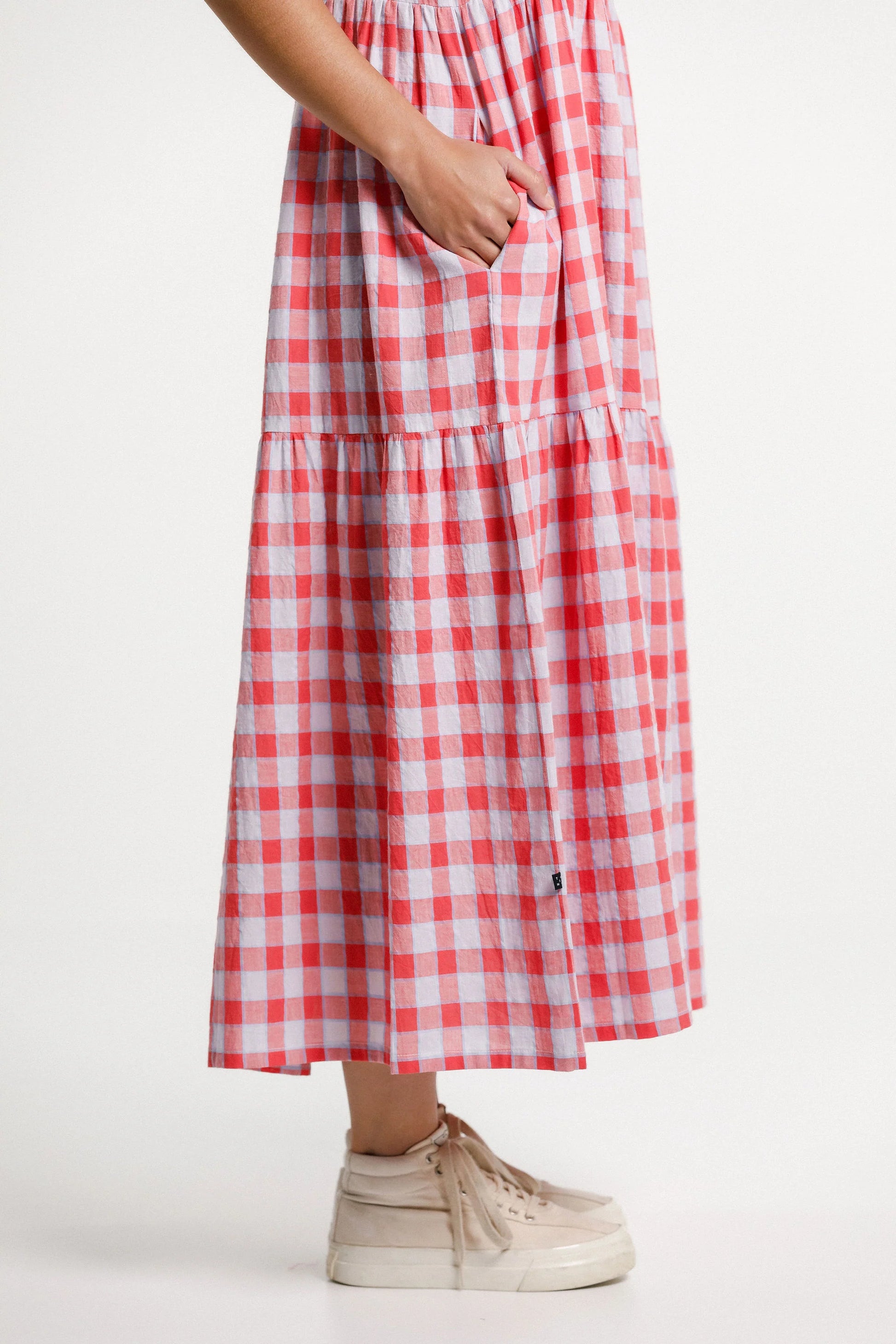 Red and white checkered dress worn by a person on a white background