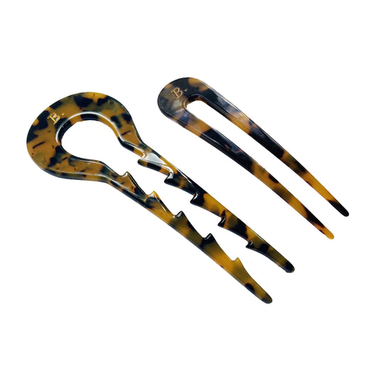 Two tortoiseshell hair combs on a white background. 