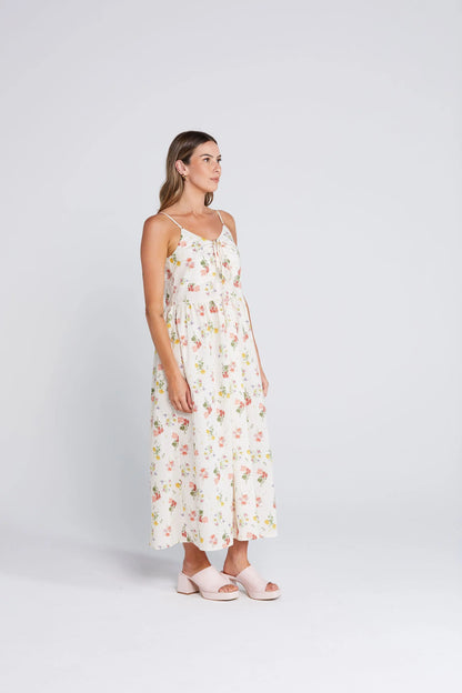 Woman wearing a floral dress on a white background. Zinnia Dress Summer Haven Side View - The Rose Edit
