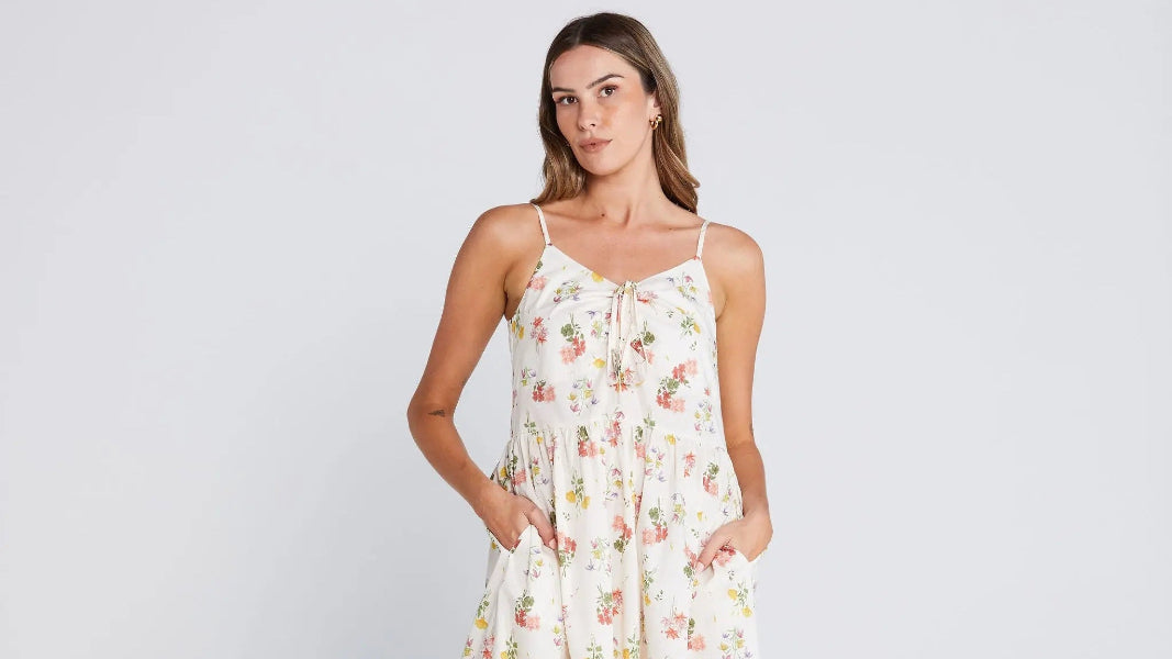 Woman wearing a floral dress against a plain background