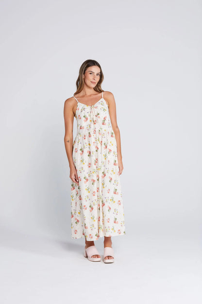 Woman wearing a floral dress on a white background. Zinnia Dress Summer Haven Front View - The Rose Edit