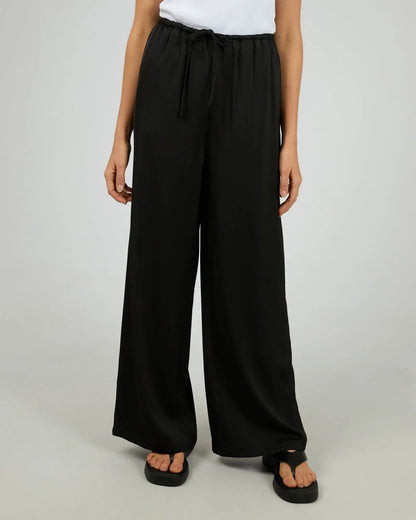 Person wearing black wide-leg pants on a plain background. Silent Theory Carter Pant Black - The Rose Edit