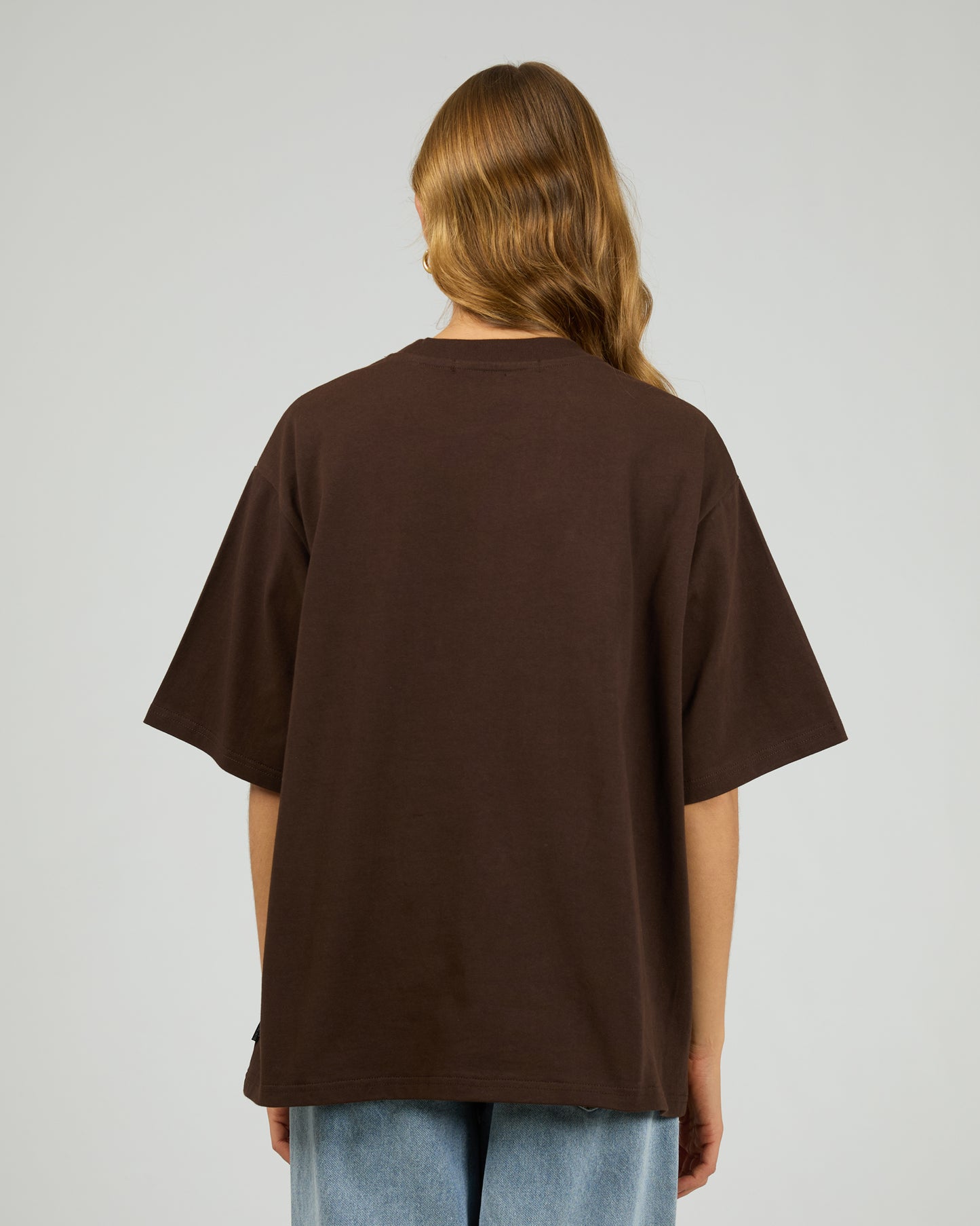 Person wearing a brown t-shirt on a plain background. Core Oversized Tee Chocolate - The Rose Edit