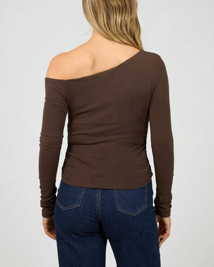 Brown one-shoulder long-sleeve top worn by a person on a plain background. Kylie Off Shoulder L/S Top Brown Back View - The Rose Edit