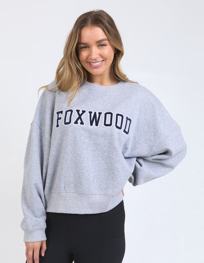 Woman wearing a gray sweatshirt with 'FOXWOOD' text on a white background
