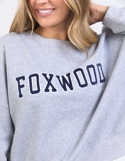 Gray sweatshirt with 'FOXWOOD' text worn by a person