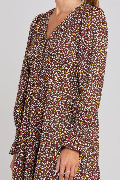 Floral patterned dress with long sleeves on a plain background